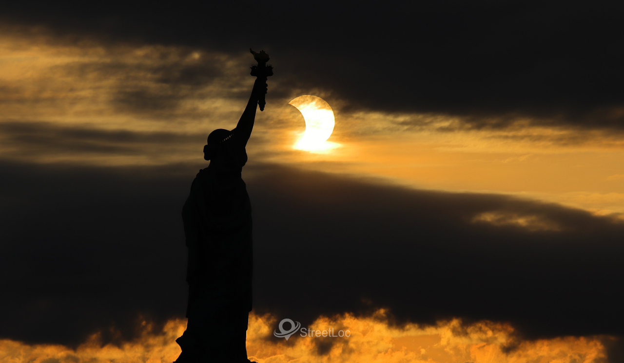 solar eclipse as the sun rose behind the Statue of Liberty